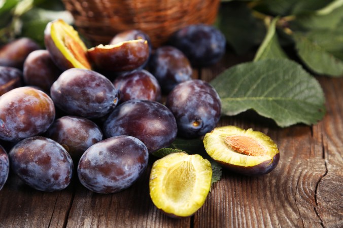 Fresh plums on brown wooden background