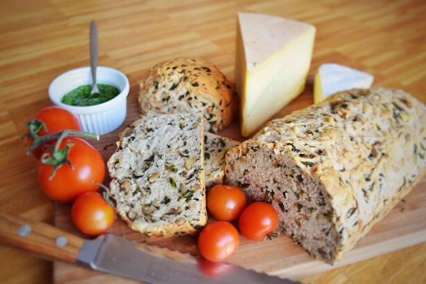 Bärlauchbrot auf Holzbrett mit Pesto und Tomaten