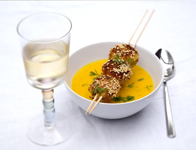 Kürbiscremesuppe in Suppenschale mit Fischfrikadellenspieß Weißwein